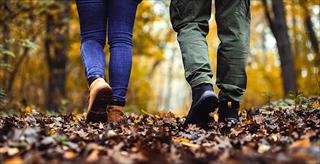 two people walking in a wooded area