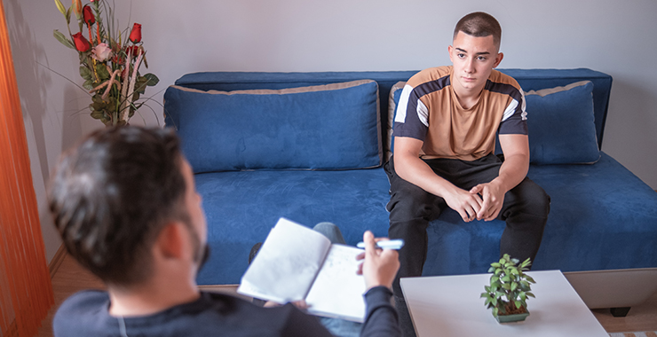 man seated on a couch in counseling session