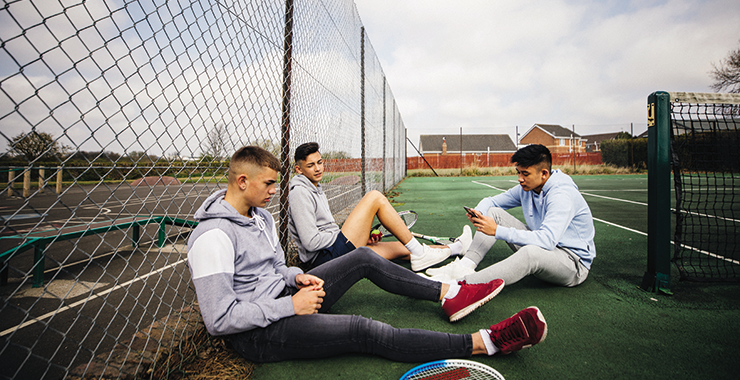 teen boys on tennis court