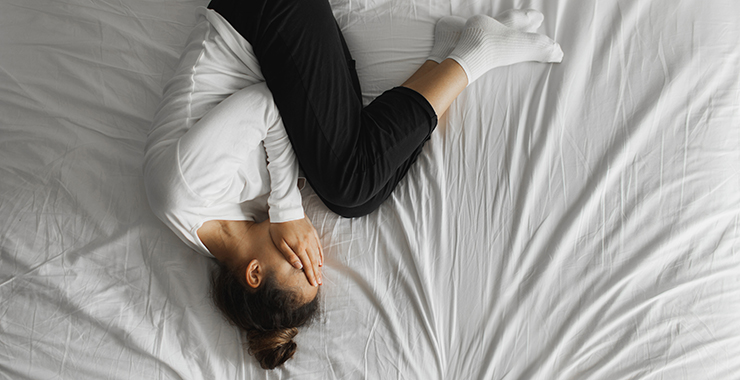 woman curled up on top of a bed