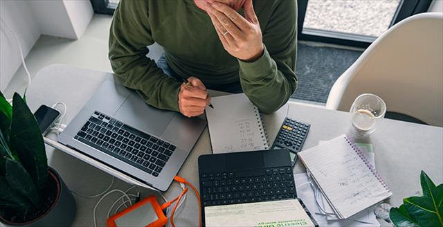 person using a laptop and a calculator