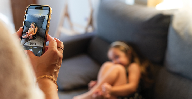 parent taking a picture of a child using a smartphone