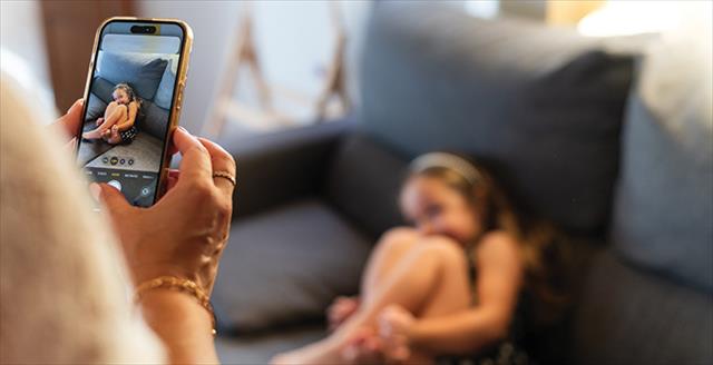 parent taking a picture of a child using a smartphone