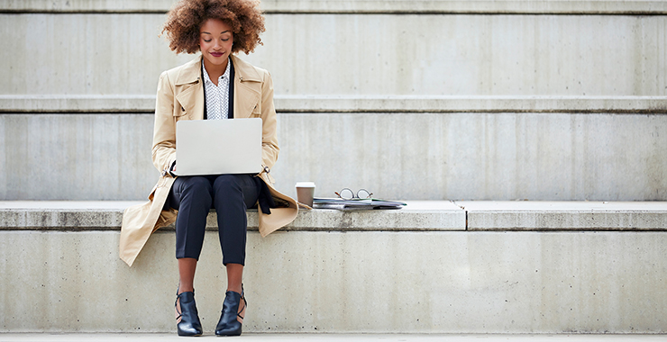 woman sitting outside with a laptop