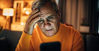 man looking at phone looking concerned