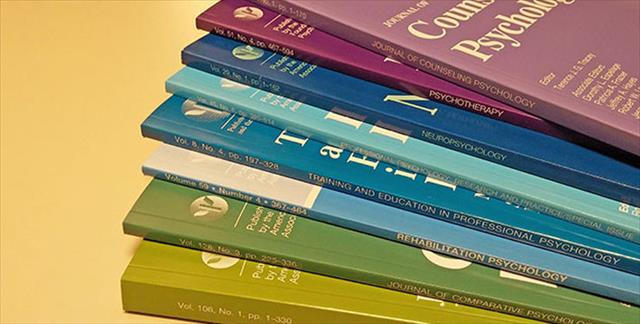 stack of APA-published journals in muted colors