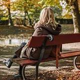 lonely woman sitting on park bench
