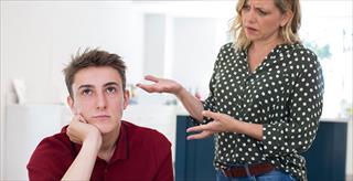 fed up teenage boy being nagged by mother at home