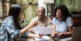 A health professional going over paperwork with a couple