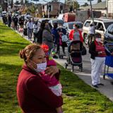 people standing in line waiting for vaccines
