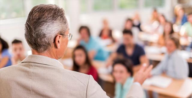 Rear view of teacher giving a lecture in the classroom