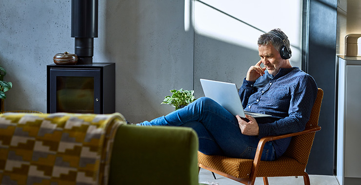 Man with earphones looking at his computer