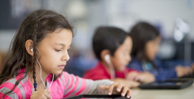 Young girl with earphone looking at tablet
