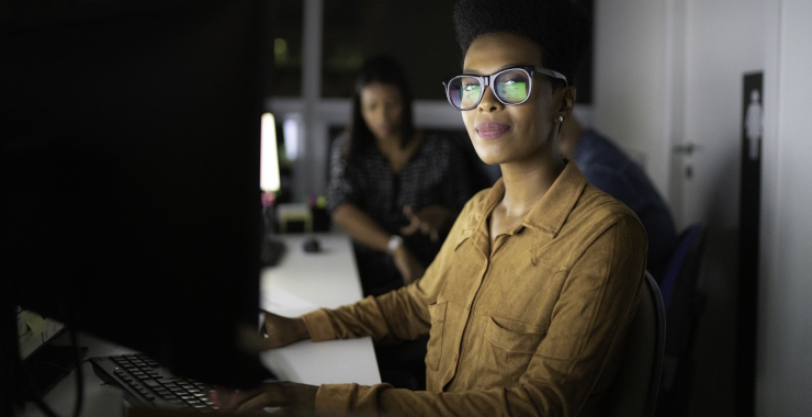 Woman with glasses sitting at her desk 