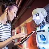 technician programming human robot through tablet PC at workshop