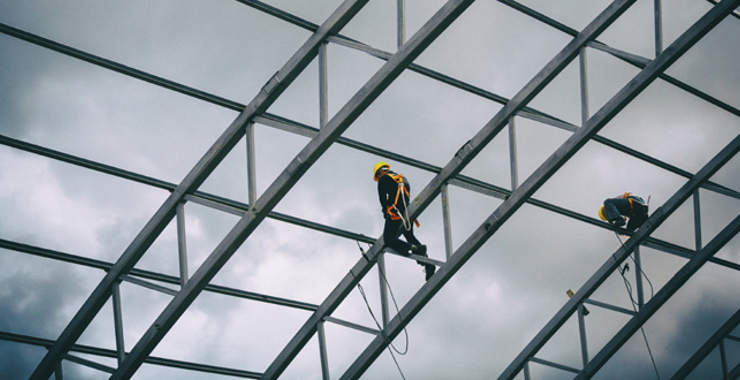 construction workers walking on scaffolding