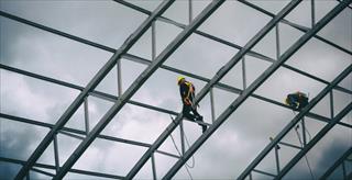 construction workers walking on scaffolding