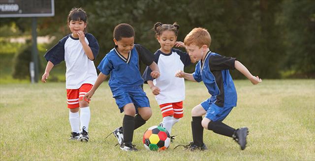 children playing soccer outside