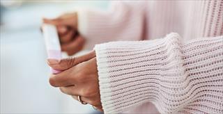 woman checking at-home pregnancy kit results
