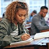 Student at desk writing in notebook