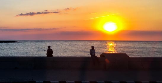 Men fishing at sunset.