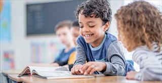 elementary school students reading together in classroom