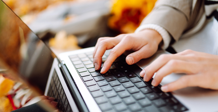 A generic image of two hands typing on a laptop keyboard.