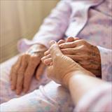 person holding an elderly woman’s hand