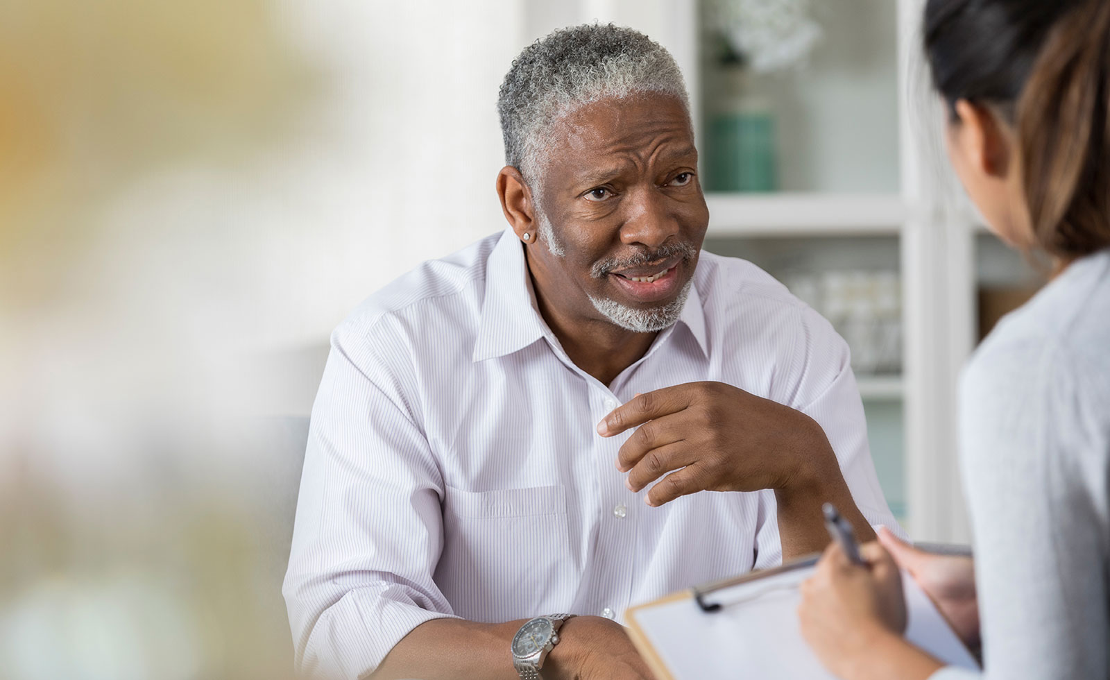 Distraught senior man talks with female therapist