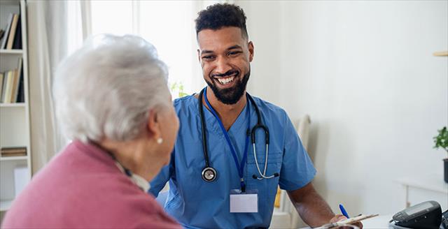 health care worker and older patient discussing treatment