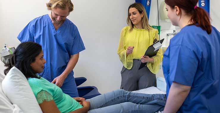 patient in a hospital bed being seen by a doctor