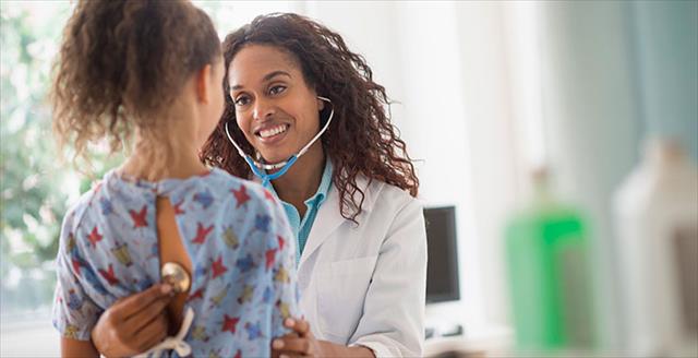 female pediatrician examining patient
