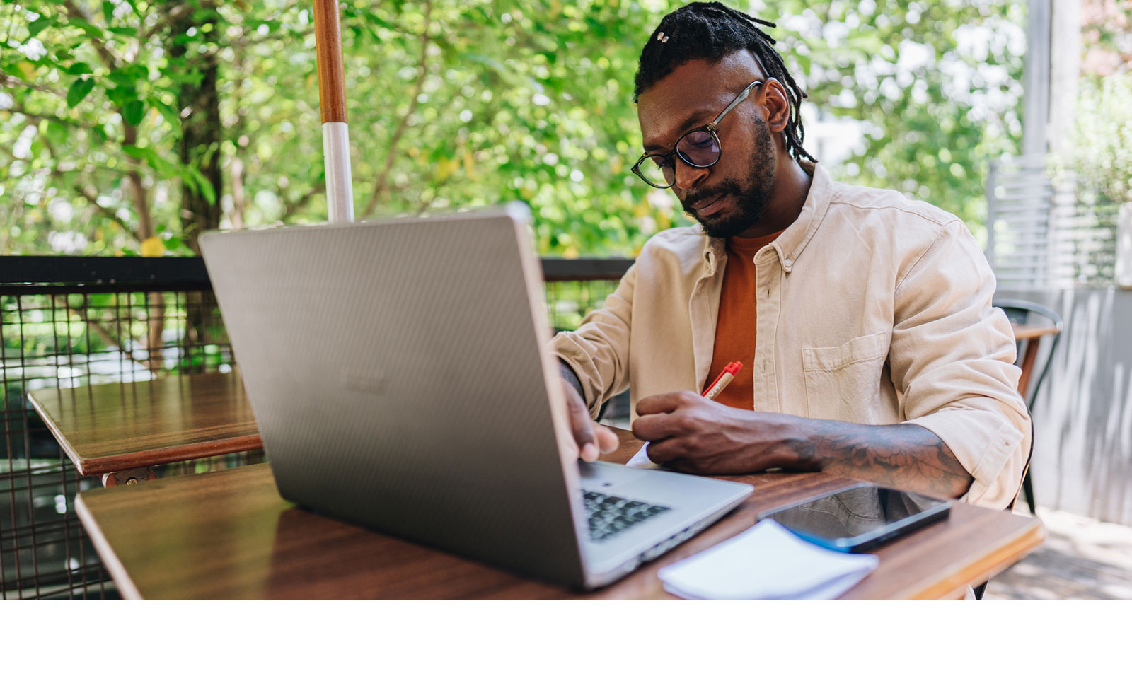 Older female professional using laptop outside.