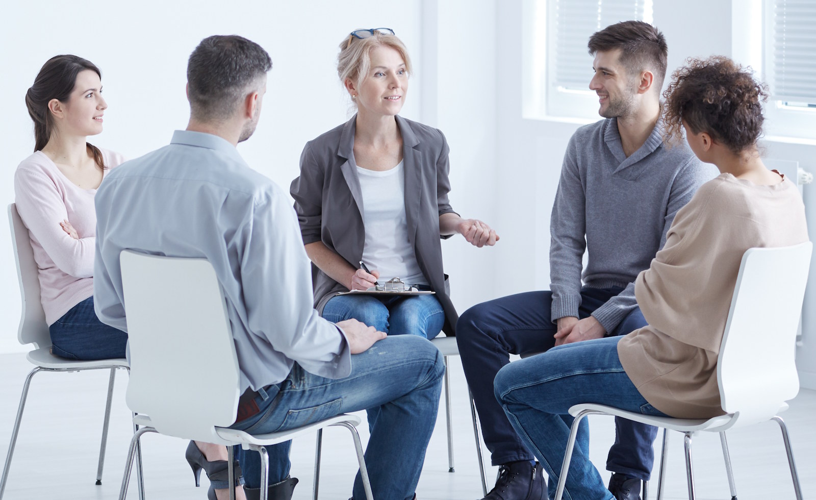 Therapist and patients sitting in circle during meeting