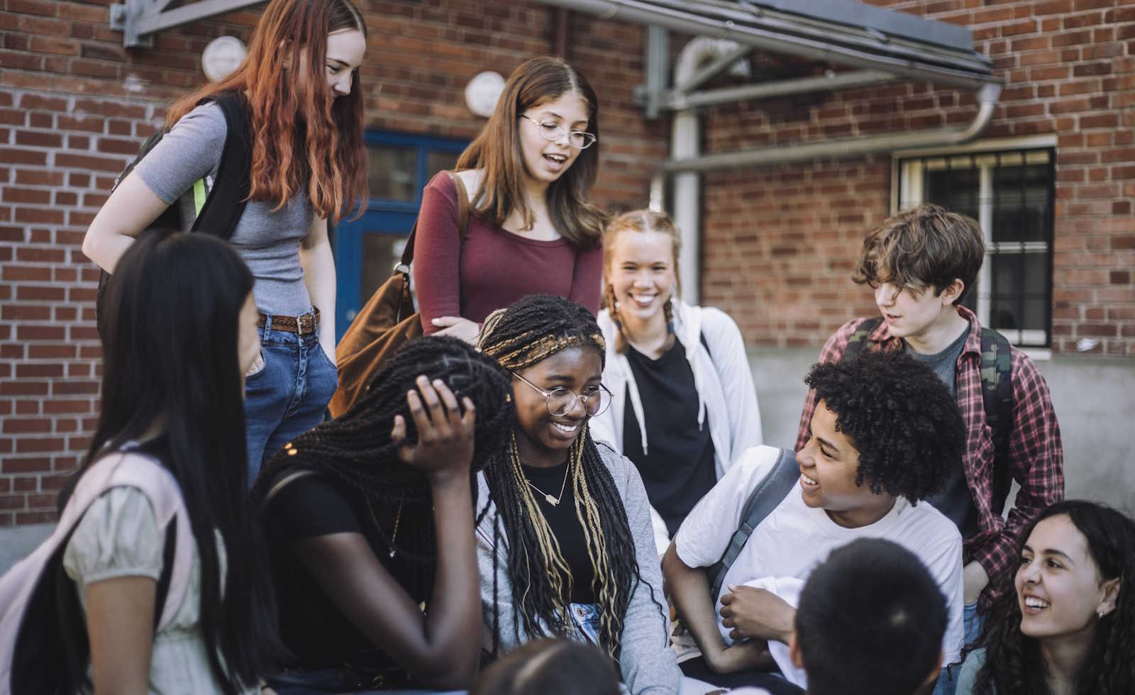 Group of young students outside of school building