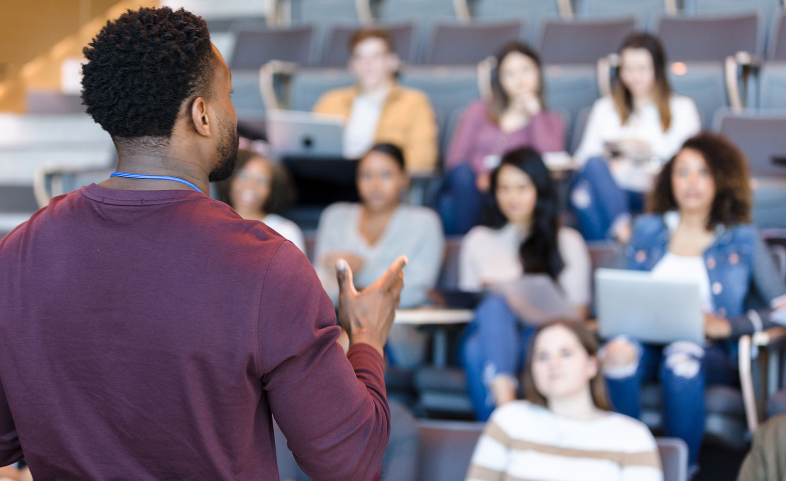 Male college professor gestures during lecture.