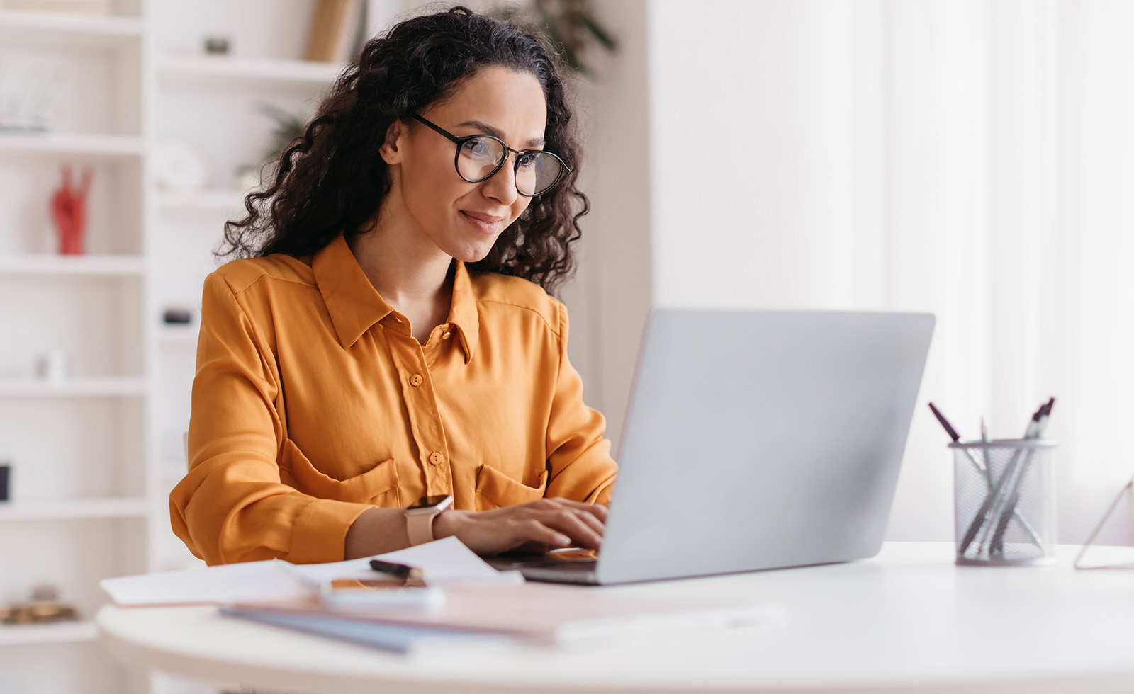 Woman with glasses glancing at her laptop