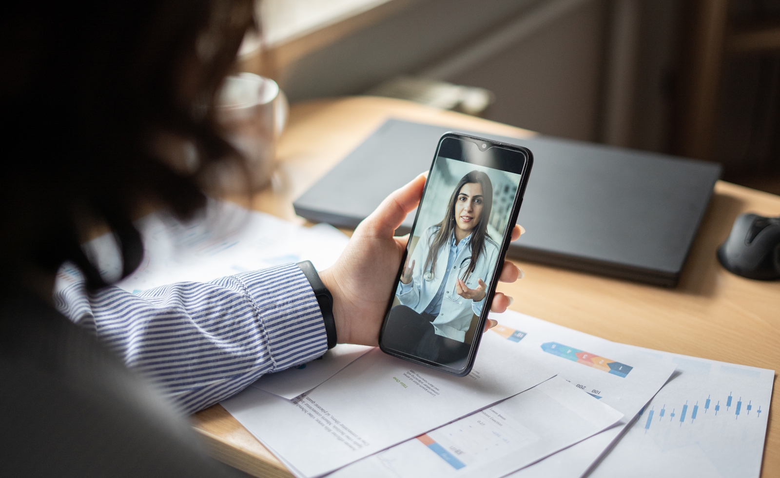 Businesswoman making video call with doctor in office