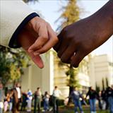 Black hand and White hand holding each other