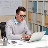 Young Asian professional using laptop.