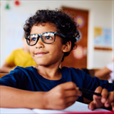 A young child with glasses in a classroom