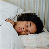 African American teenage girl asleep in bed.