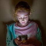 Tween girl staring at a smartphone