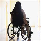 Young woman sits in wheelchair; her back is to the camera.
