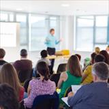 A man presenting to a group of people, engaging them with his speech