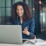 Woman with earphones smiling in front of laptop