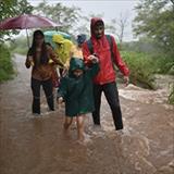 Young family walking down flooded road