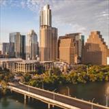 The image shows the downtown skyline of Austin, Texas, viewed from the south across Lady Bird Lake