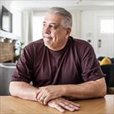 Man sitting at a table with a concerning facial expression