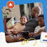 A dad sits on the couch with his kids using handheld devices